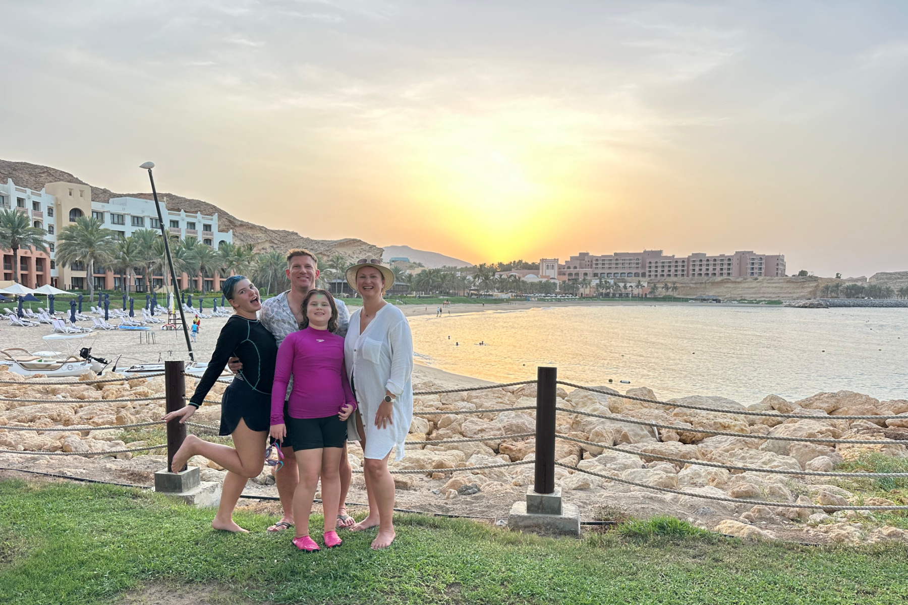My family standing in front of the sunset at the Hilton Al Bandar hotel complex