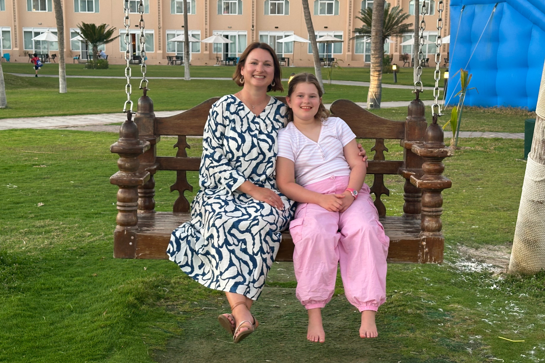 My daughter and I sat on a chair swing at the Crowne Plazas Salalah. I am wearing a long dress and my daughter is wearing a t-shirt and long trousers