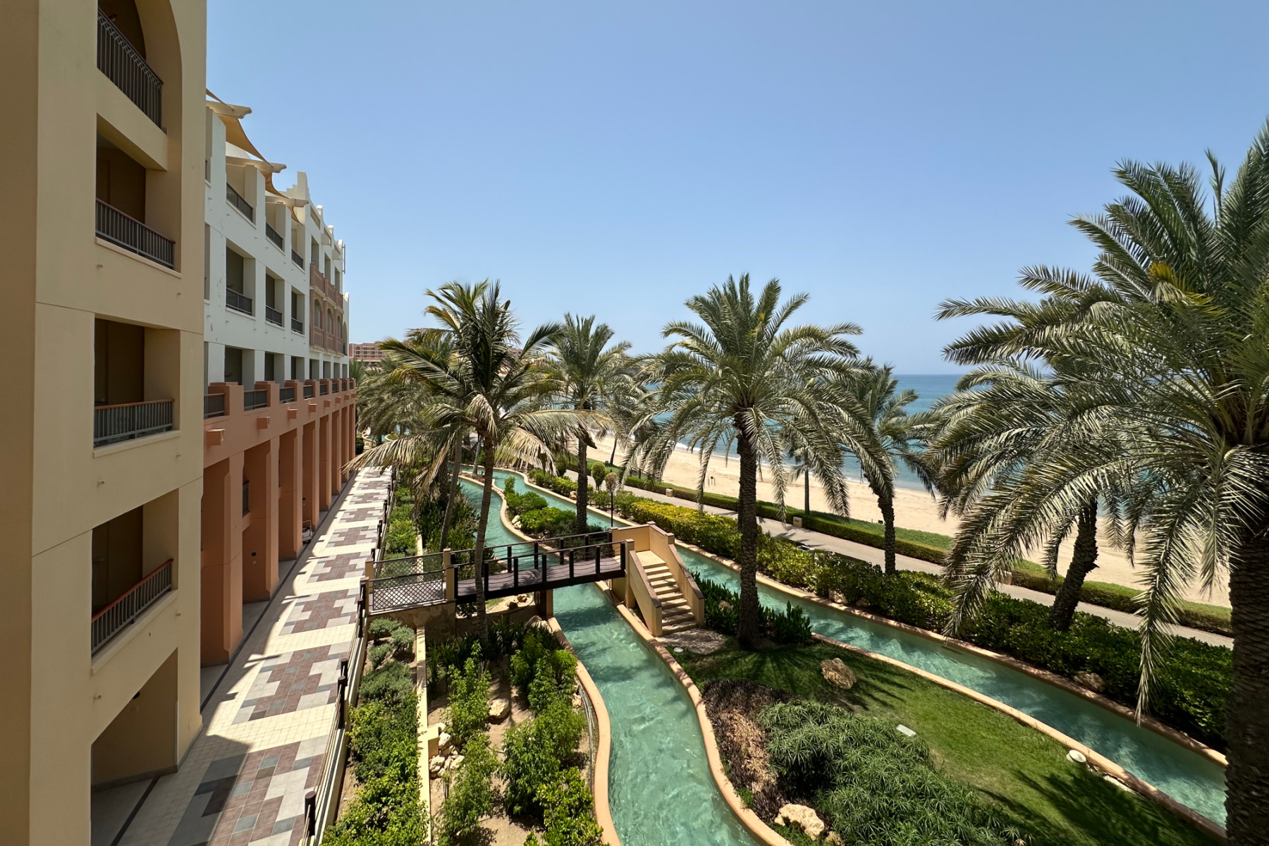 A view of the lazy river, palms and beach from our Connect Family room in the Al Waha hotel