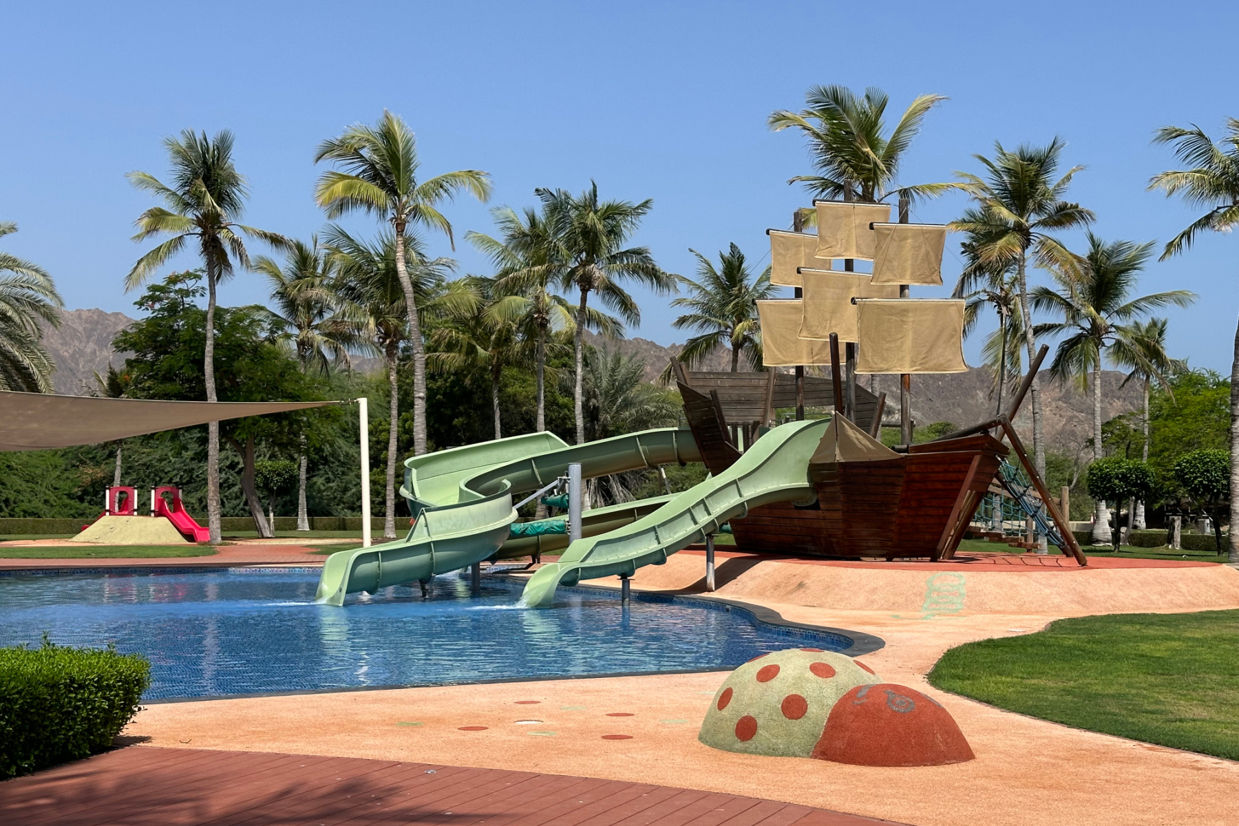 The children's pool with two slides going down into the water from a pirate ship
