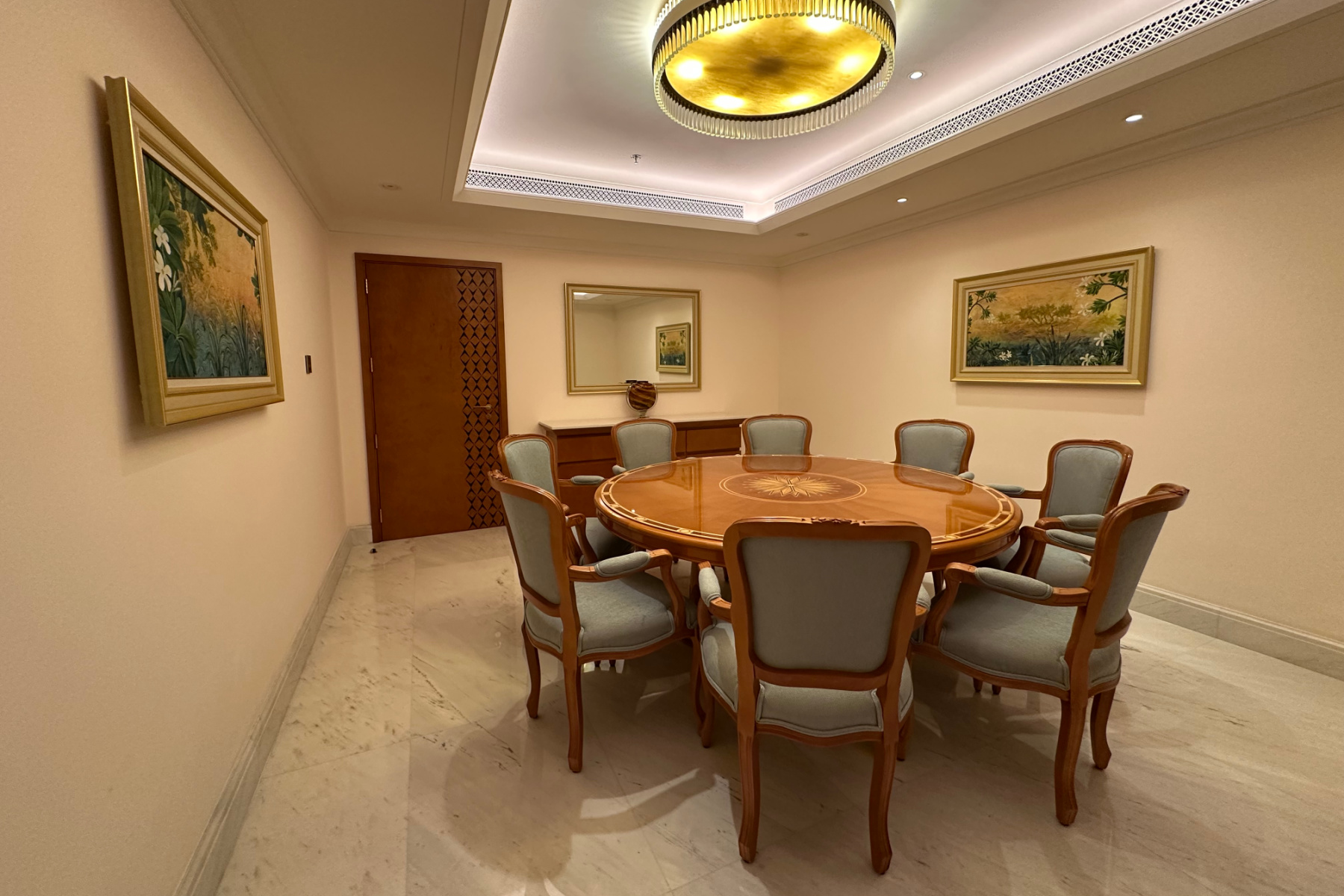 The dining room in the Sohar Suite at the Al Bustan Palace. A polished table with eight chairs is in the middle of the room