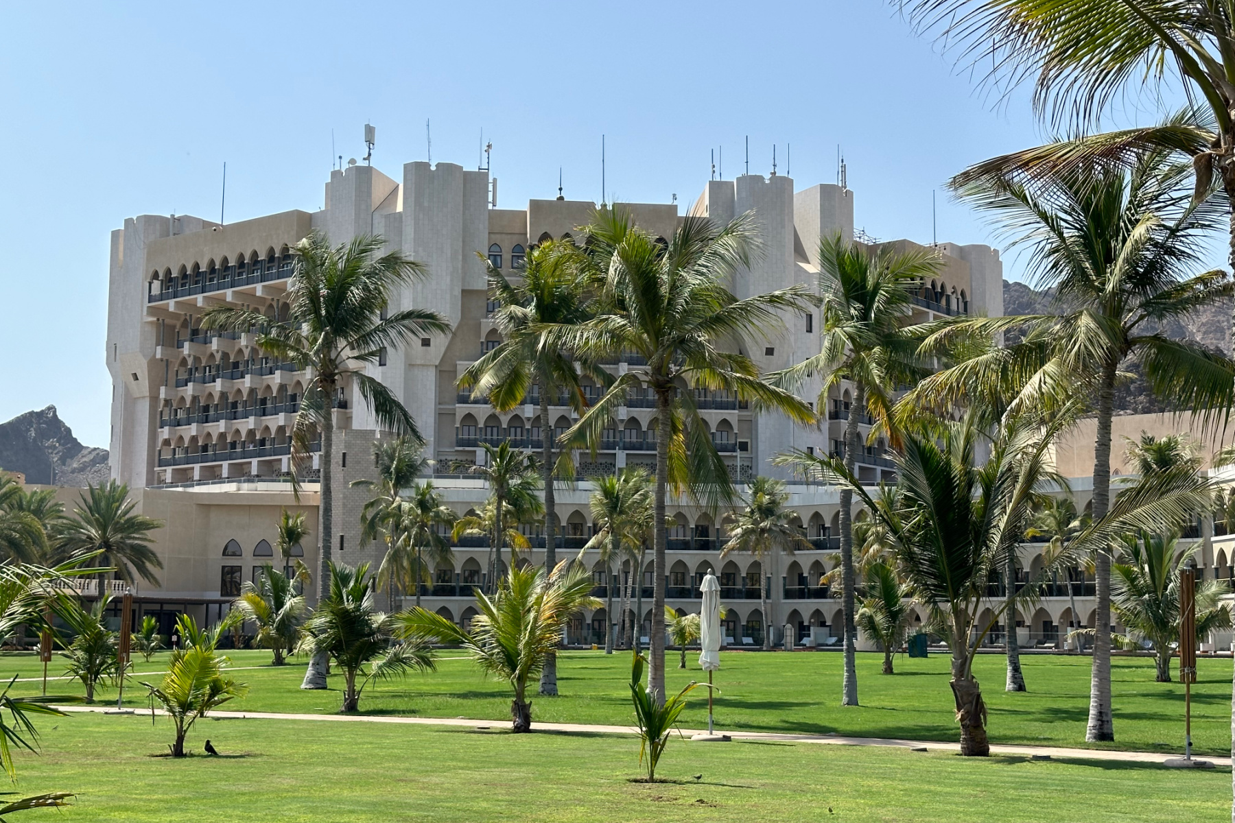 A view of Al Bustan Palace hotel in muscat seen through palm trees planted in the extensive grounds