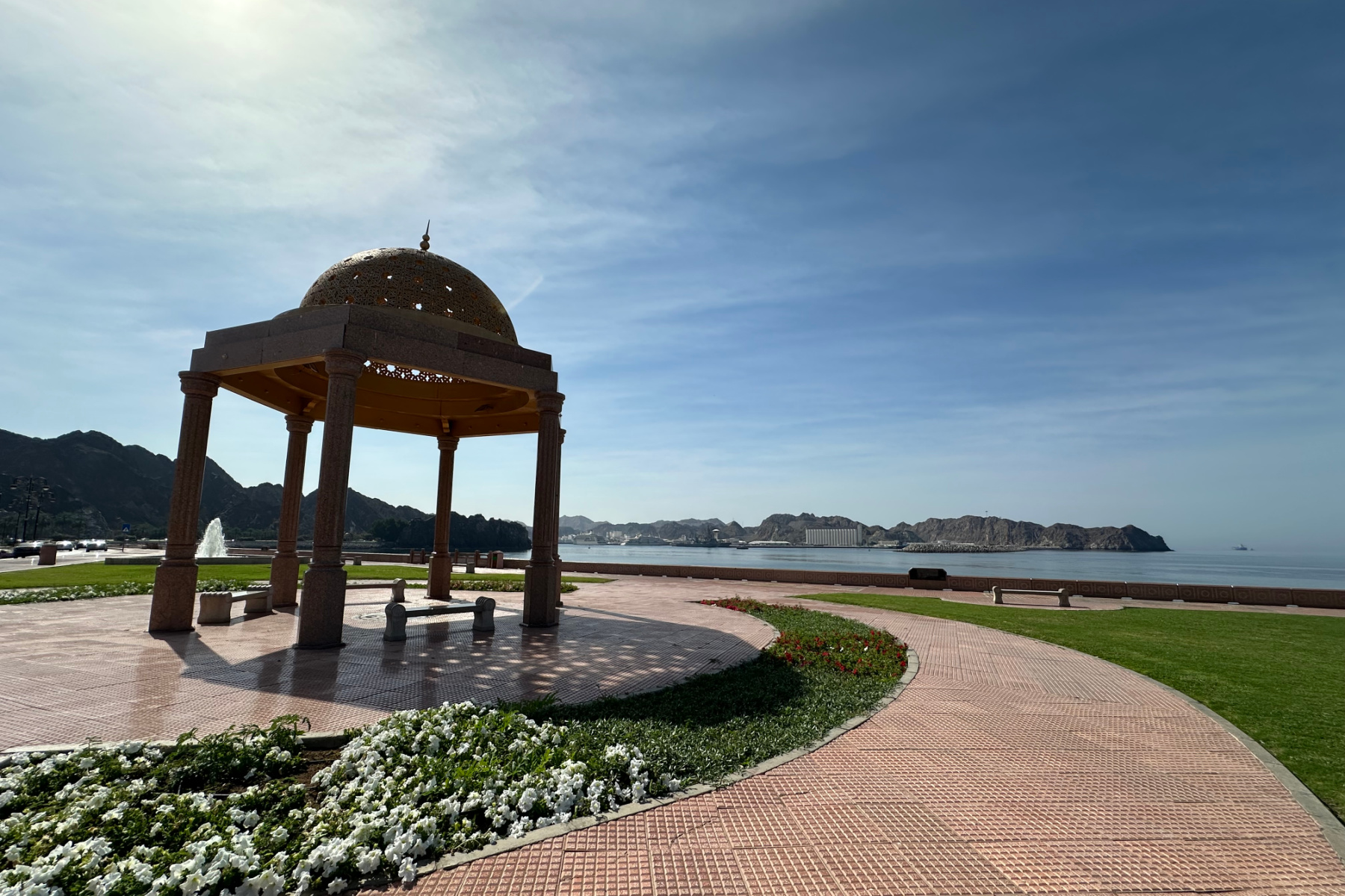 A gazebo shelter on the corniche at Muttrah with a view of the port in the background