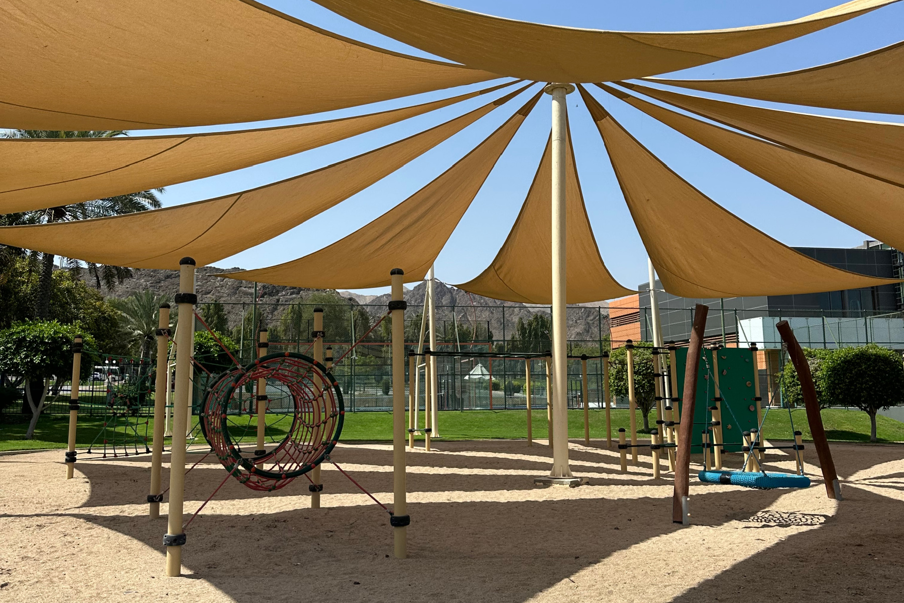 The children's play equipment under a shade in the grounds of Al Bustan Palace