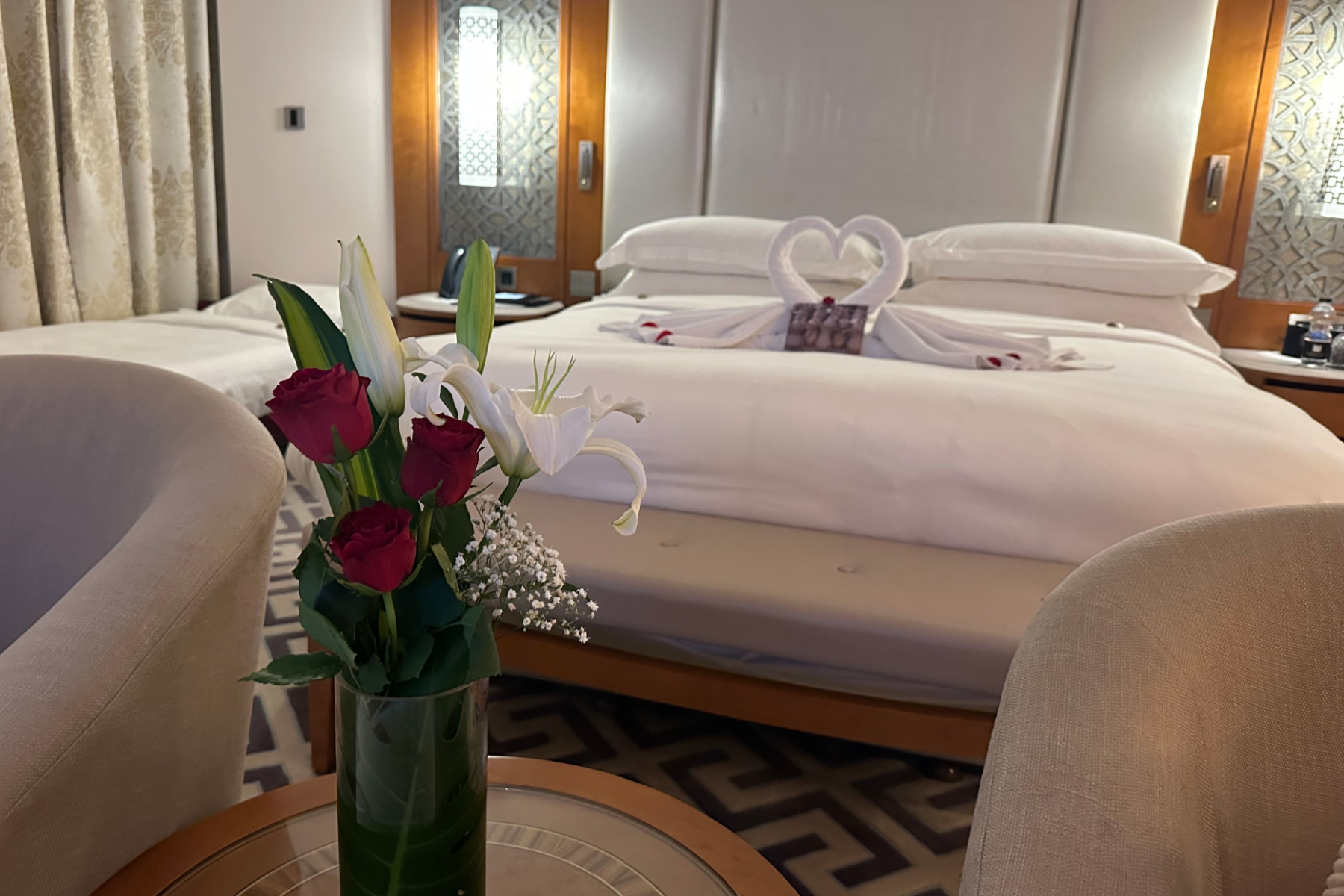 A vase of red roses left in front of the master bed