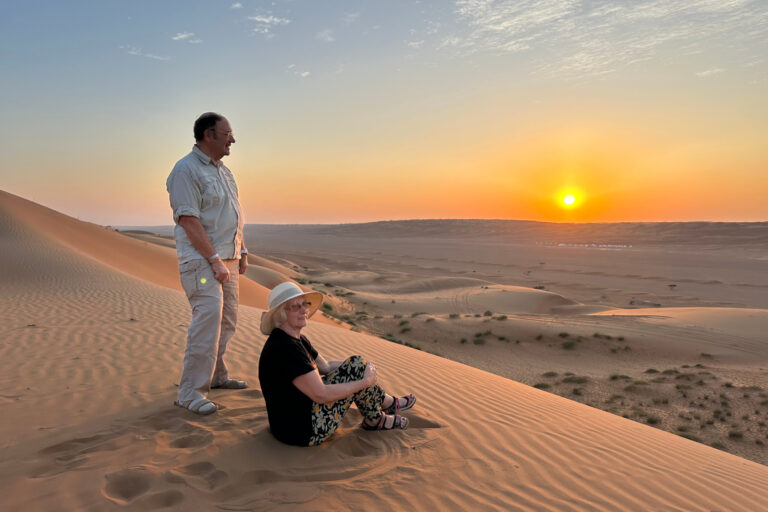 My parents at the top of a sand dune in Wahiba Sands watching the sun set
