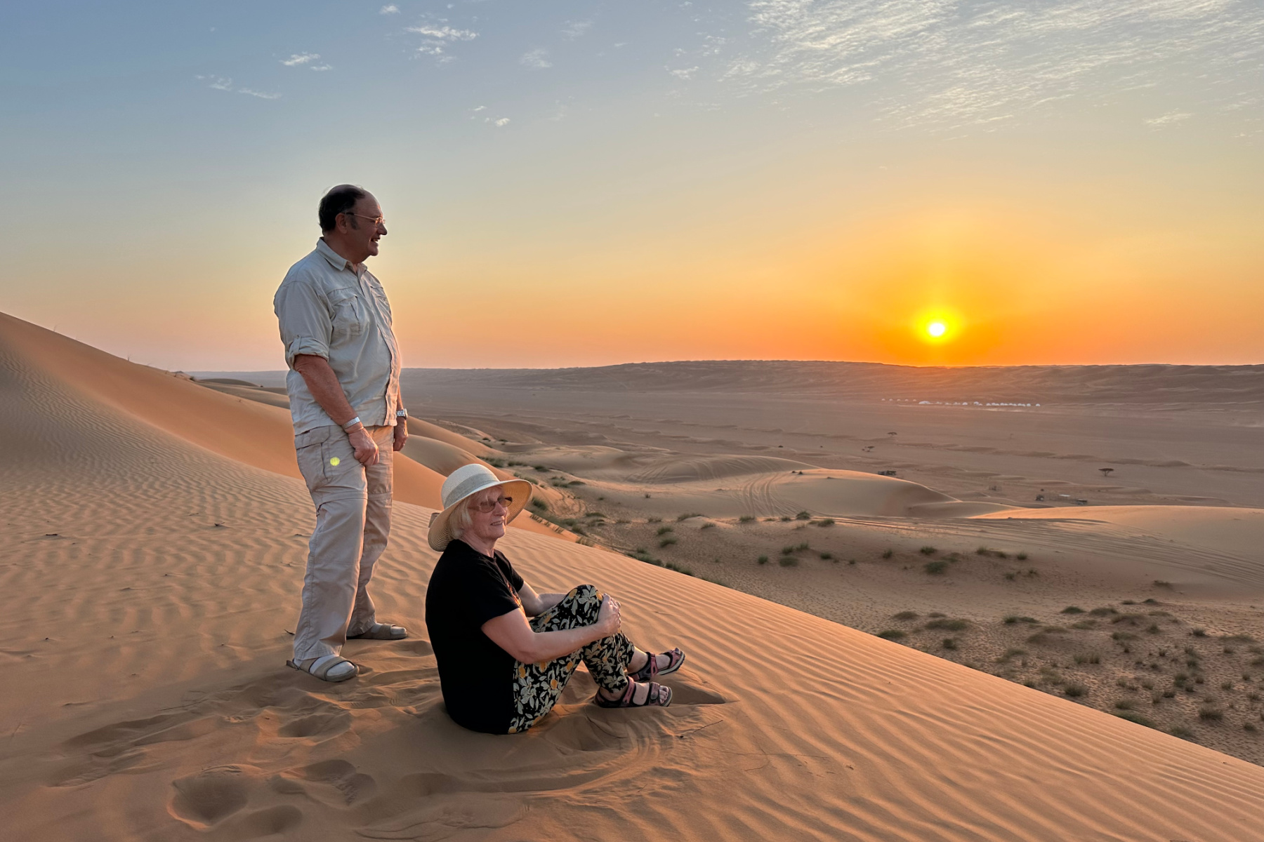 My parents at the top of a sand dune in Wahiba Sands watching the sun set