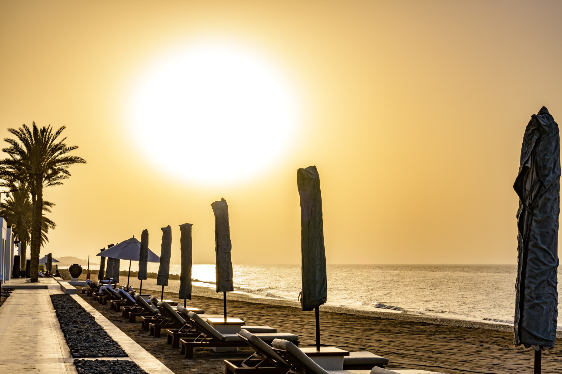 A view along the private beach at The Chedi hotel in Muscat at sunset