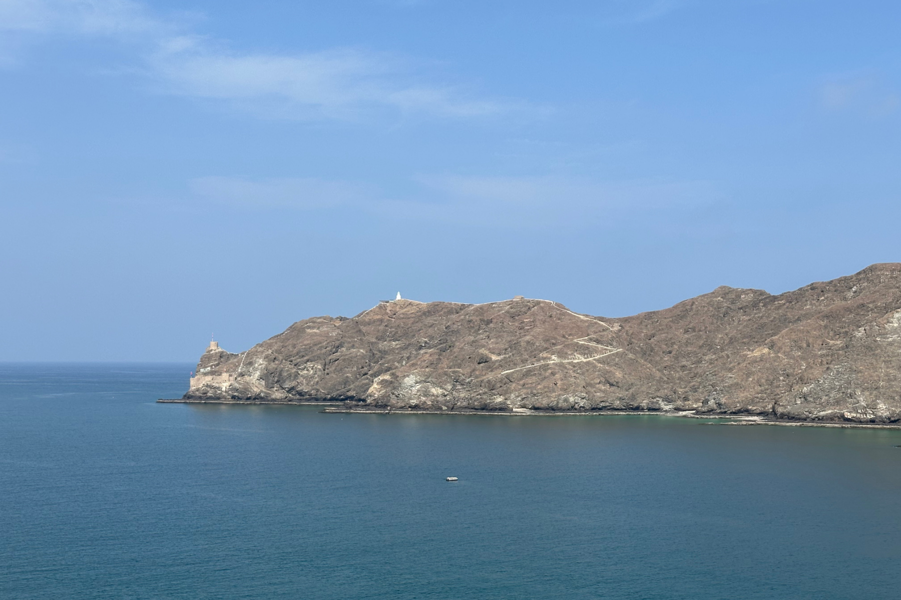A view of the bay and lighthouse beyond Al Mirani Fort towards the Sea of Oman