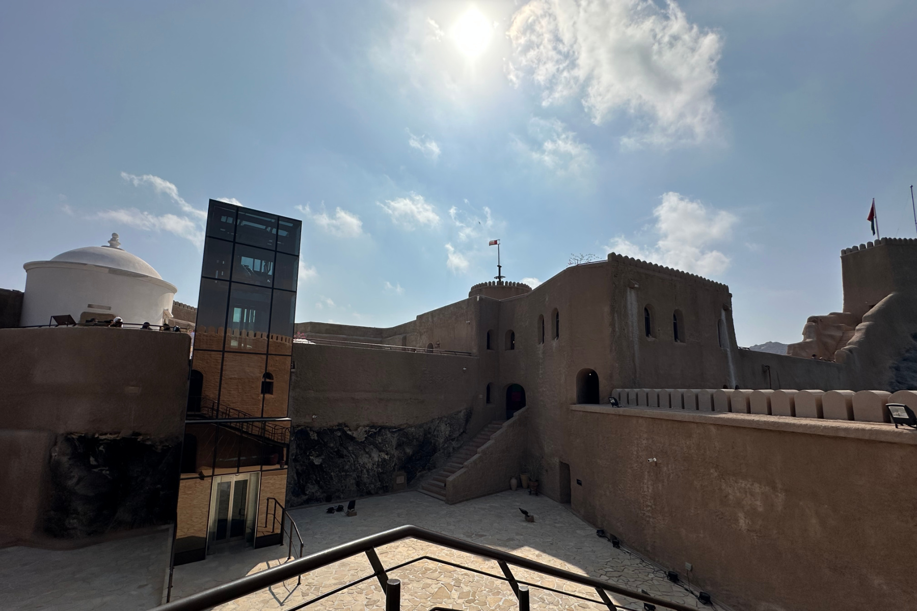 The main courtyard of Al Mirani Fort with a large glass structure for the lift shaft