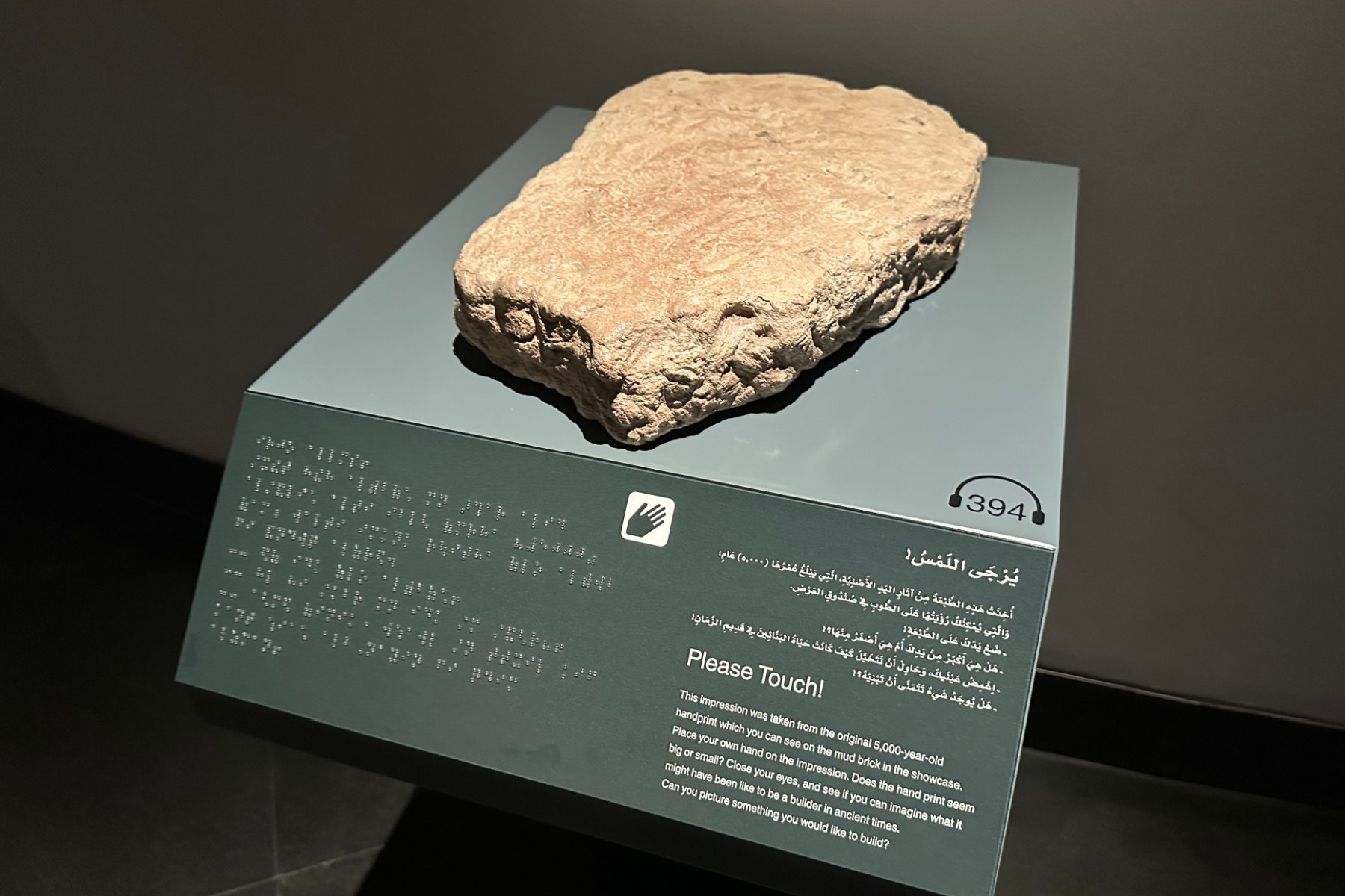 A casting of a 5000-year-old hand print that was found in a mud brick in Al Ayn. It is displayed with braille, Arabic and English information as well as an audio guide number