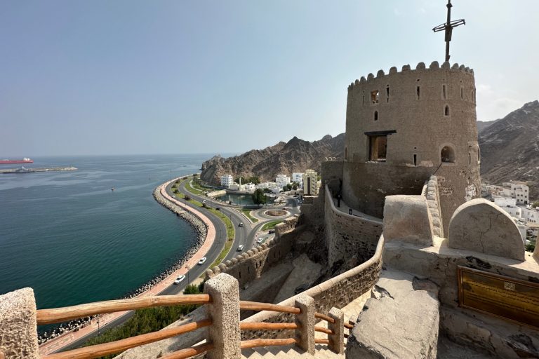 A view past one of Muttrah's towers over the port